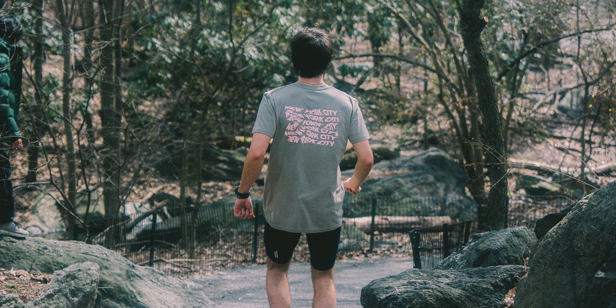 Runner wearing a tee with 'New York City' text on the back in various forms of stretched movement.