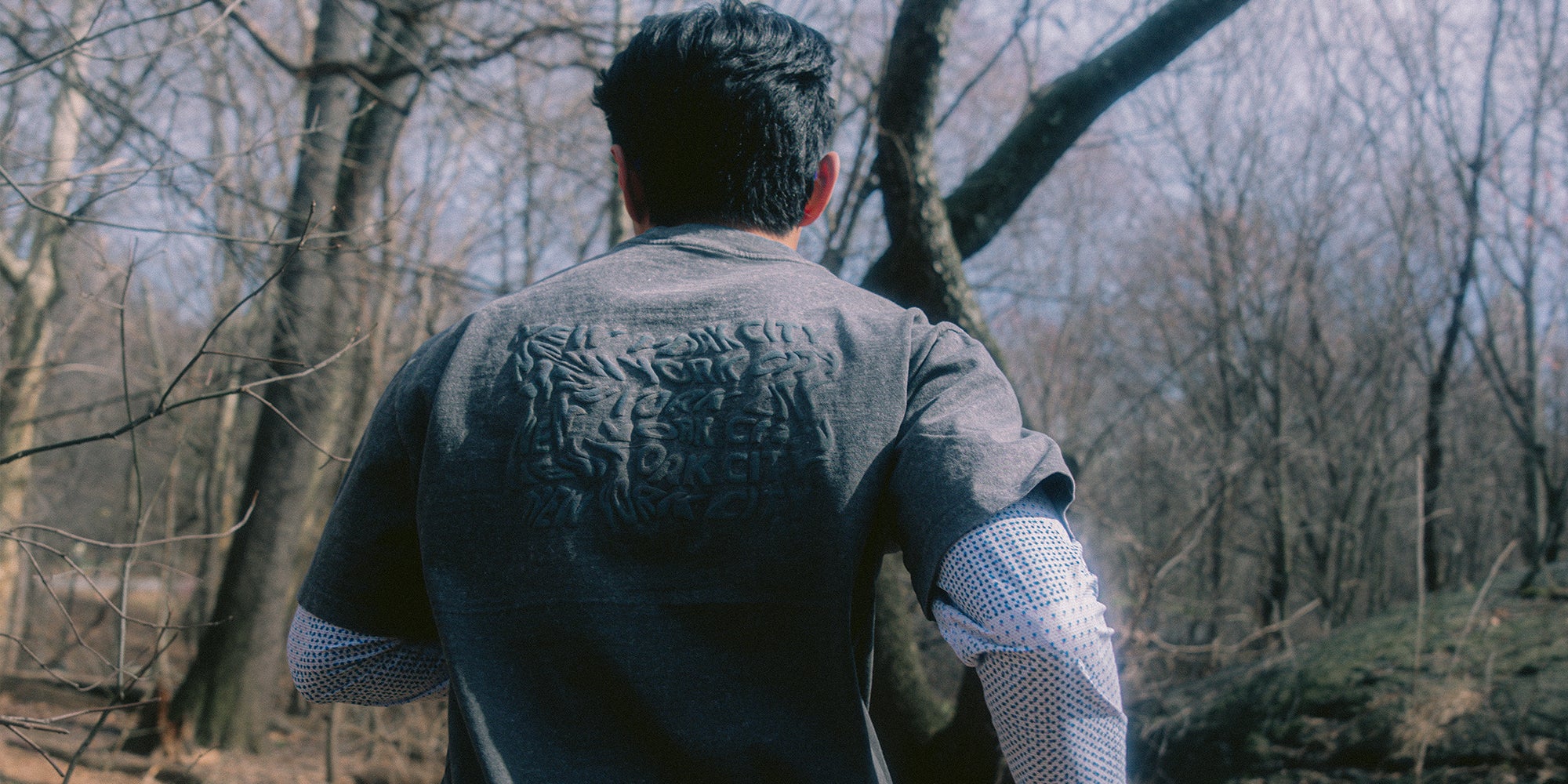 Runner wearing a tee with 'New York City' text on the back in various forms of stretched movement.