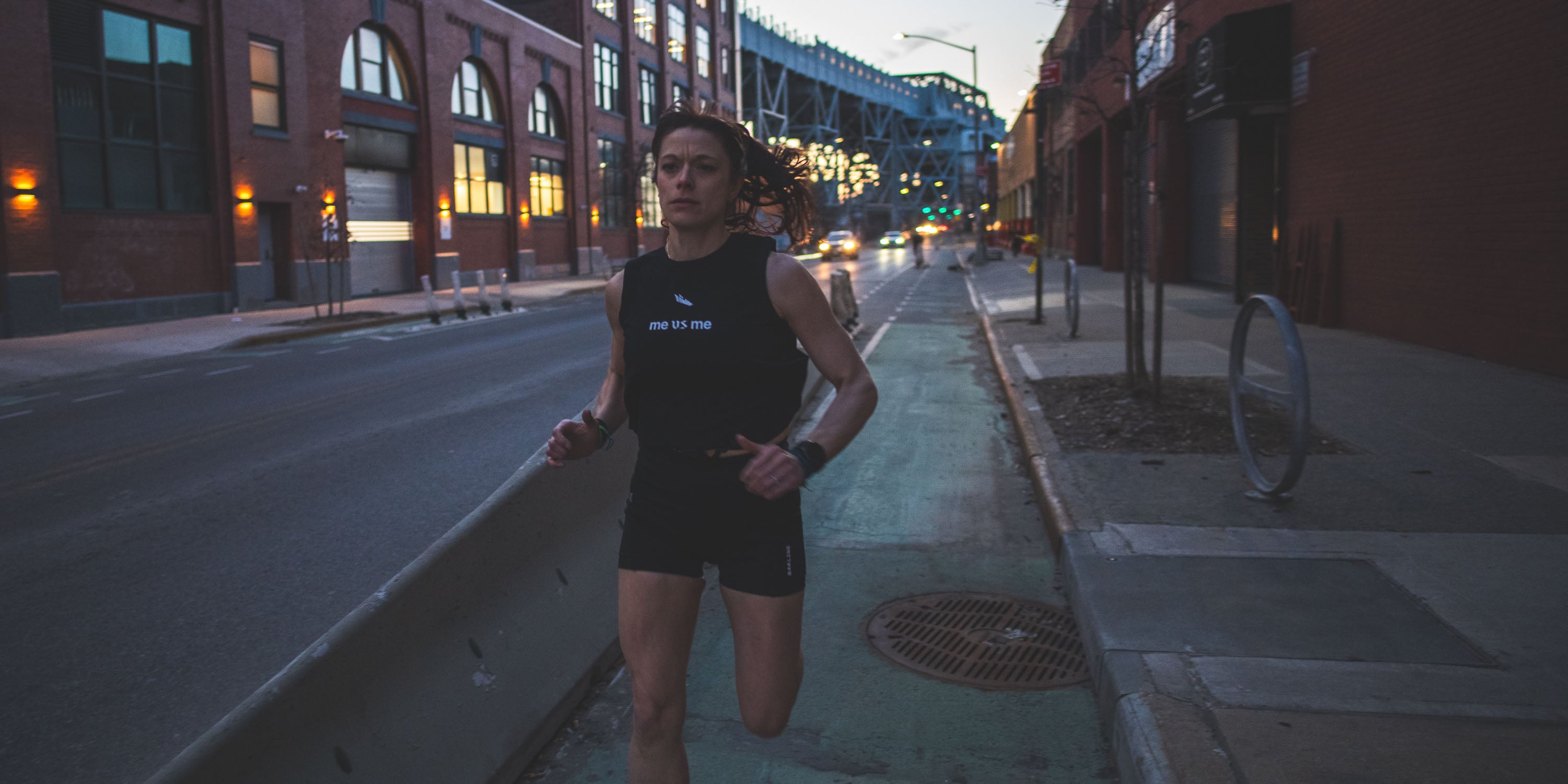 Runner on NYC streets with black cropped tank that says Me Vs Me.