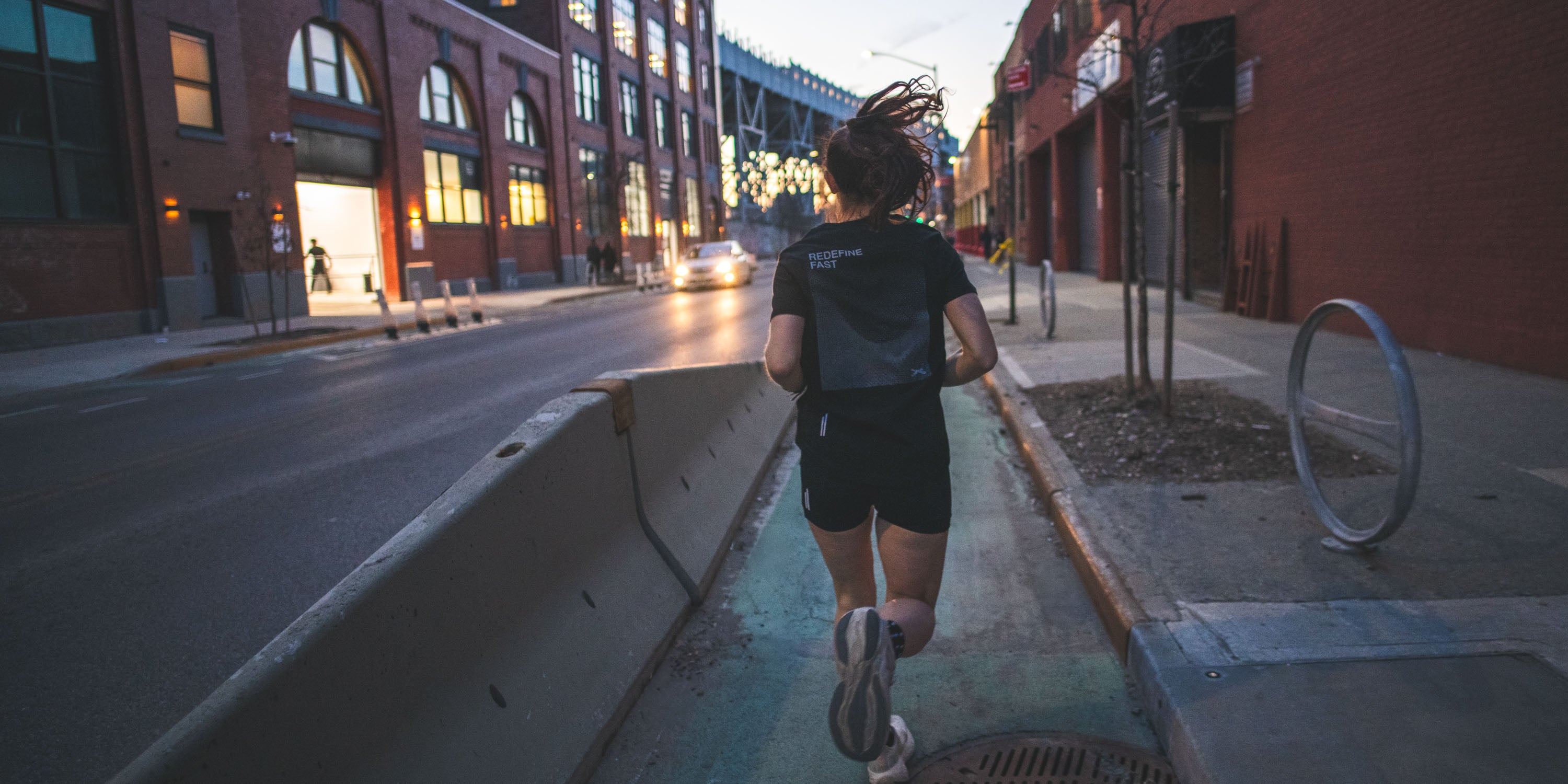 Runner on NYC streets, with black tee that says redefine fast.