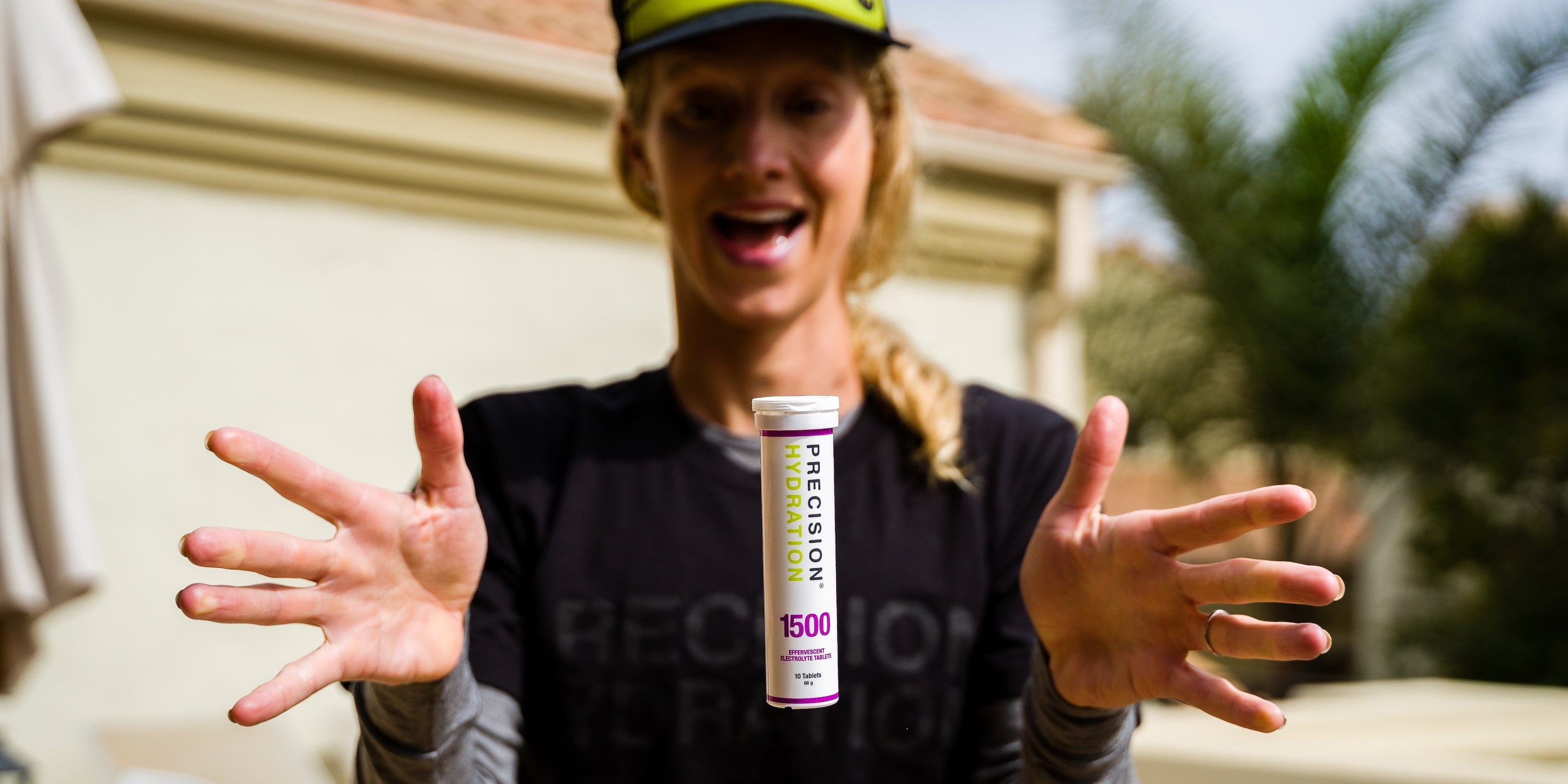 Person holding a supplement container labeled 'Precision' outdoors