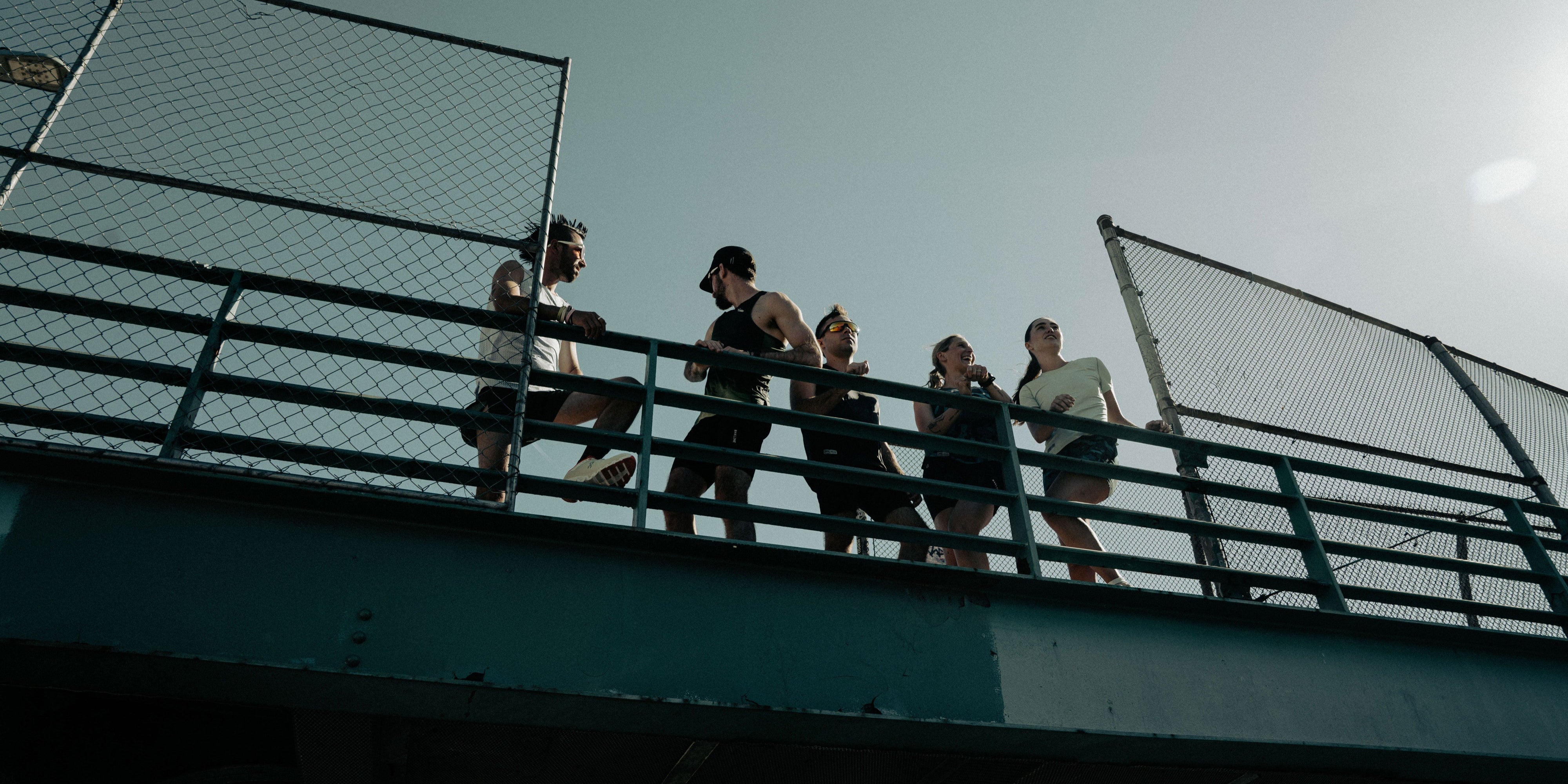 Group of people standing on a metal platform with a clear sky background